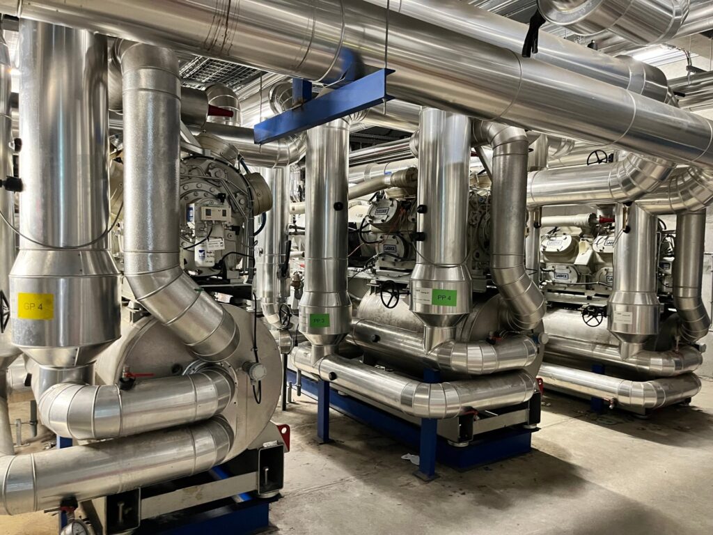 Salle des machines à l'ammoniac de la patinoire de Grenoble : compresseurs et tuyauteries calorifugées